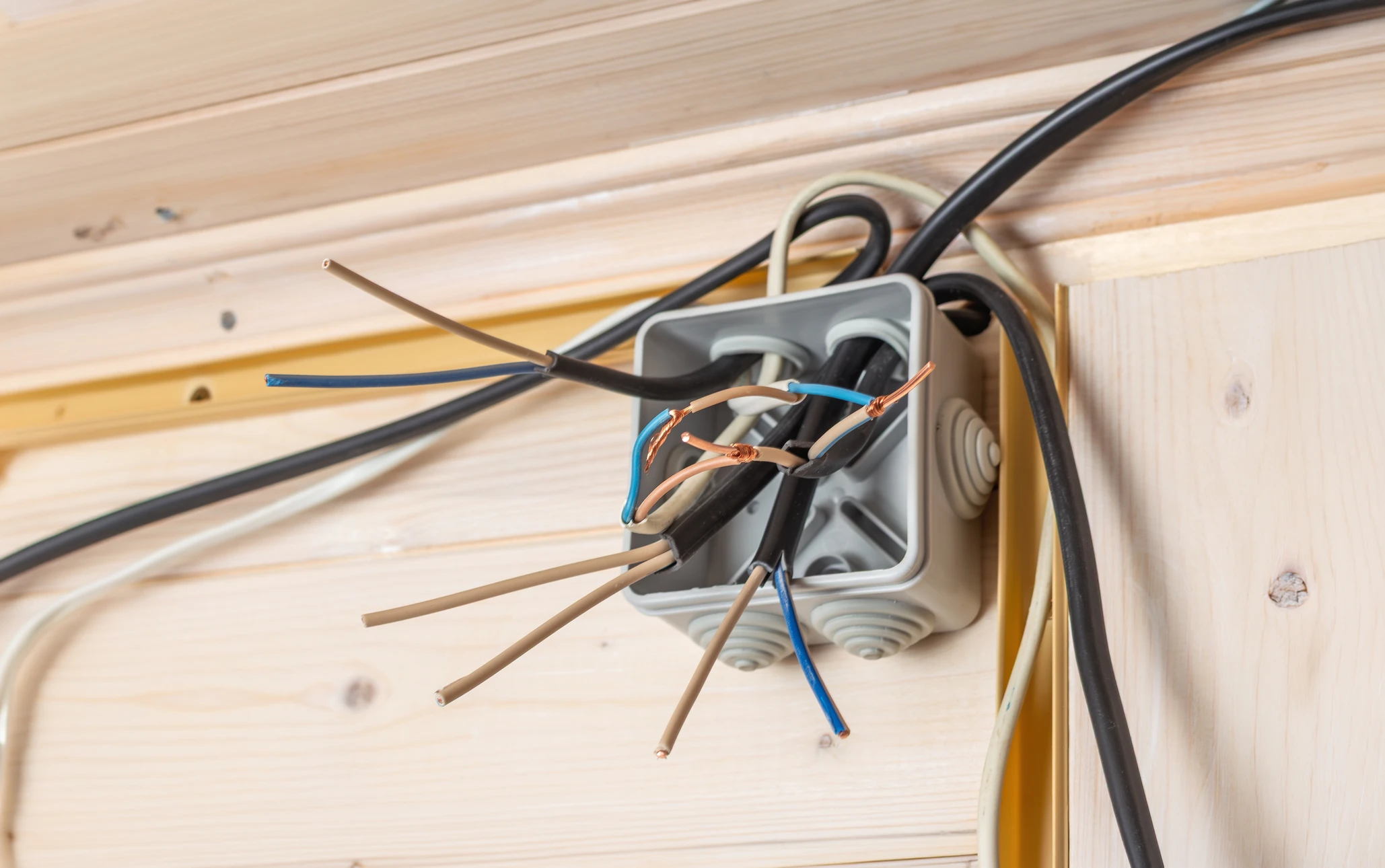 Une femme en vêtement noir utilise un système de sécurité mural installé sur un mur de briques blanches