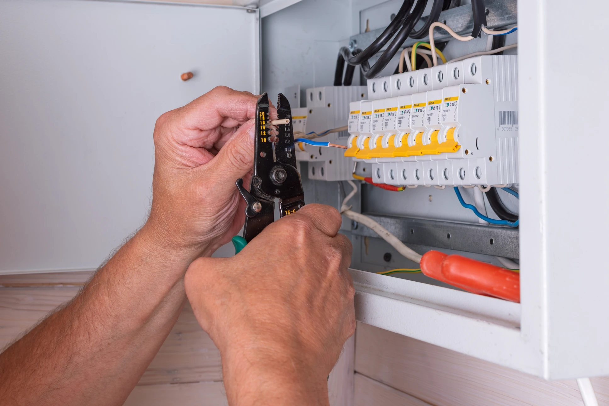 Un électricien installe une prise électrique murale dans un intérieur résidentiel